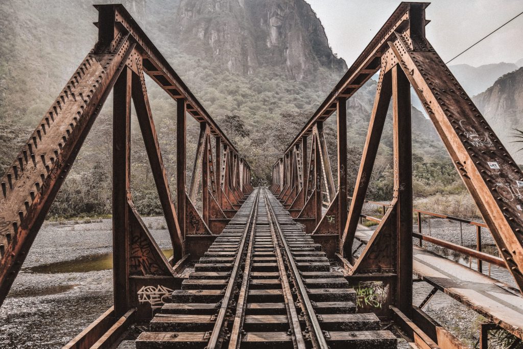 Rustic railroad tracks leading towards foggy mountains